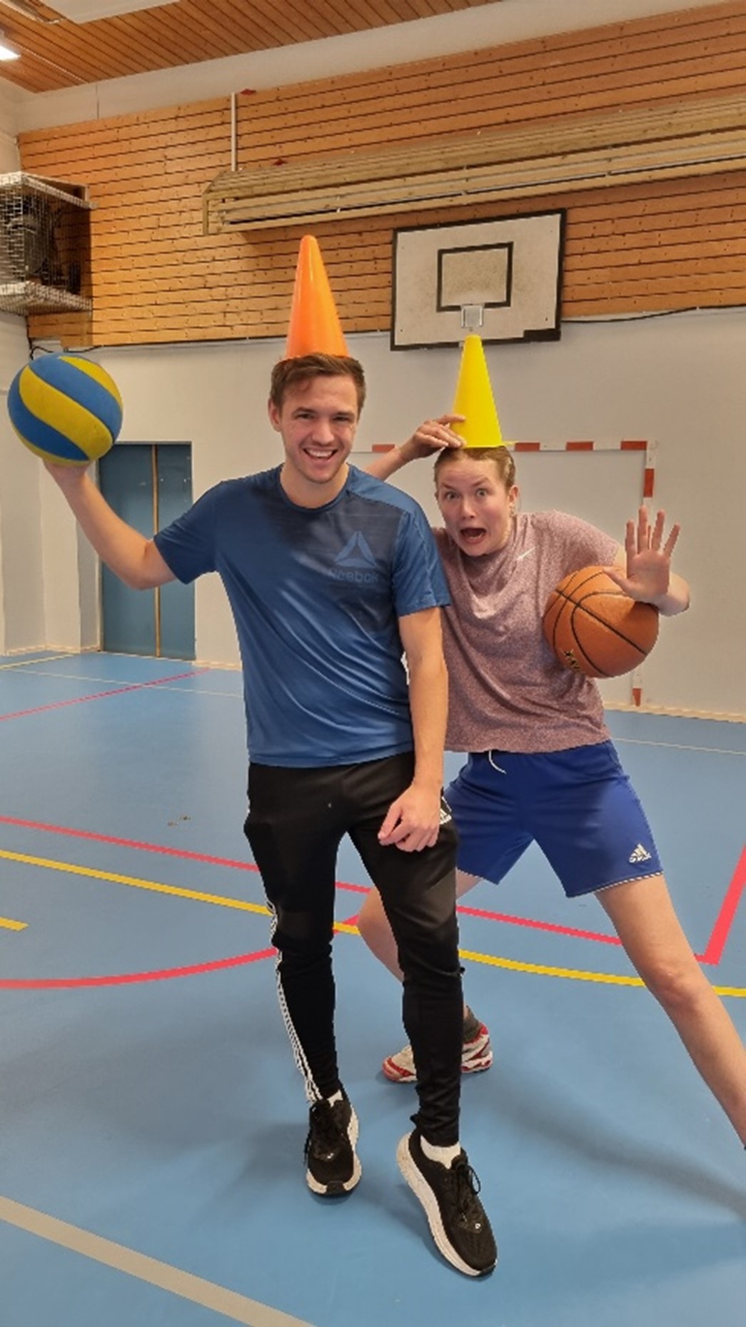 To gutter poserer i gymsal med ball