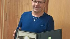 Synstolkning: Bildet viser Rolf Rånes som har mottatt Norges Vel sin diplom og medalje