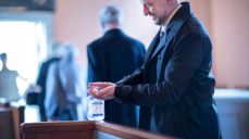 Fra dåp i Fenstad kirke i koronatiden, håndsprit står utplassert i kirkebenken. Foto: Bo Mathisen.