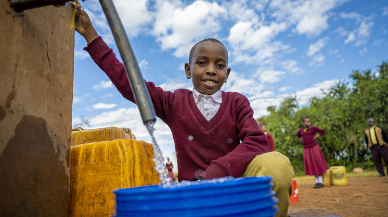 Shedrack Gaspa Urasa er 9 år og bor i en landsby som heter Goje. Etter at landsbyen han bor i fikk vann, har moren hans fått mulighet til å begynne å studere. Foto: Kirkens Nødhjelp