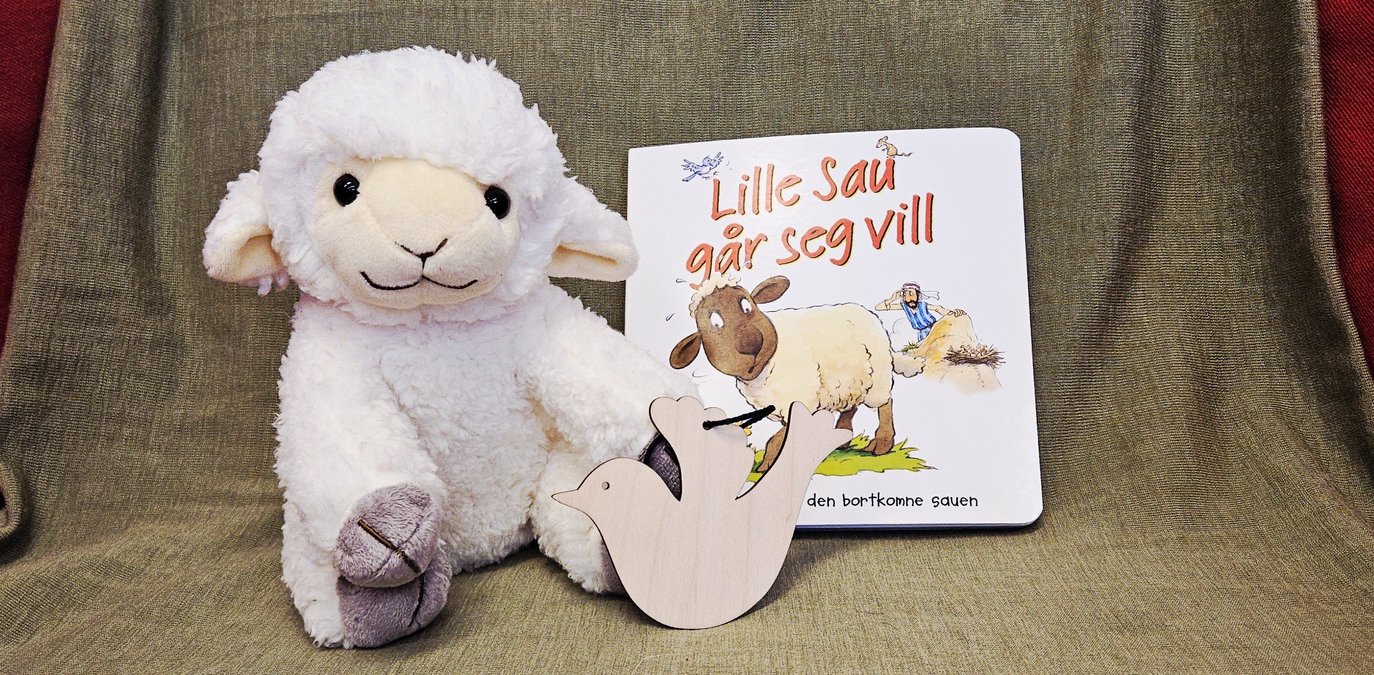 Bilde av lammet Krølle, en bok og en dåpsdue