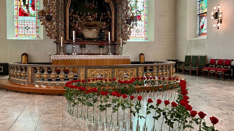 77 røde roser i formen av et hjerte foran alteret i Oslo domkirke.