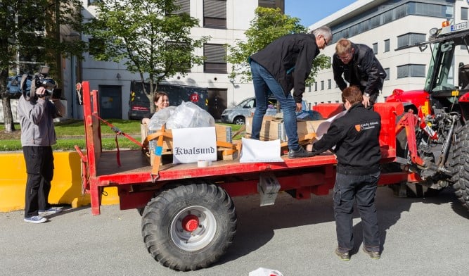 Steinene blir lastet opp på piler i forkant av prosesjonen fra havna til Stavne gravlund