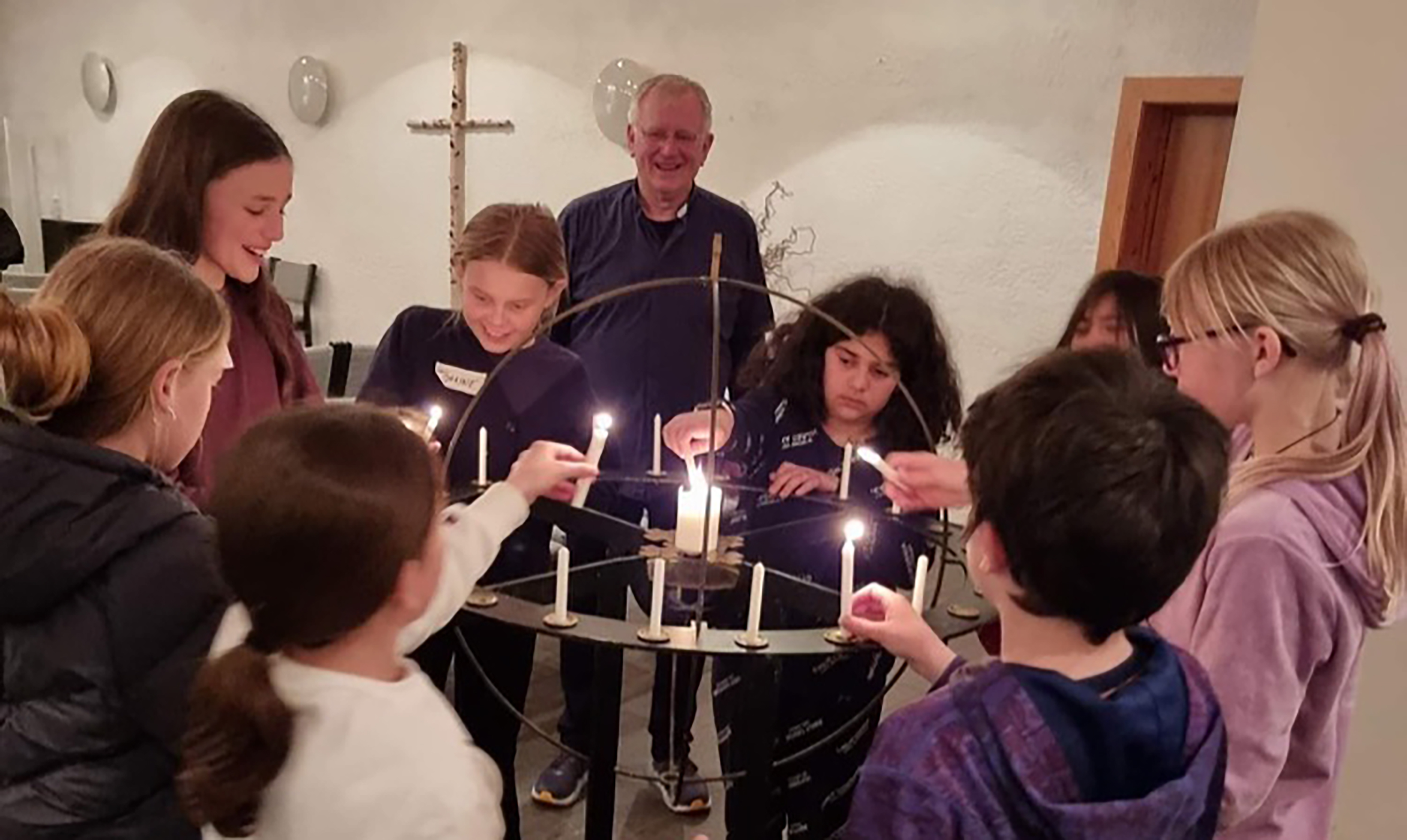 Sokneprest Sigmund B. Kruse og en av gruppene på Lys våken 2022 tenner lys og ber bønner for kvelden