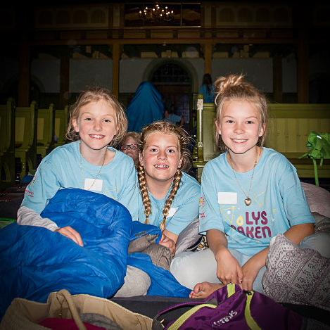 A group of girls sitting on a bed

Description automatically generated