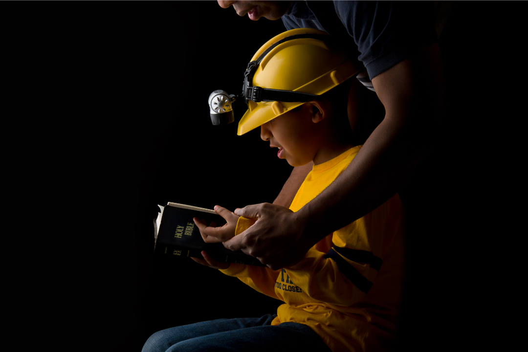 Ungdom som sitter i mørket og leser en bibel