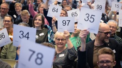 Selv om det all votering på Kirkemøtet nå foregår digitalt, stiller alltid medlemmene opp på et bilde som viser manuell votering. Foto: Den norske kirke