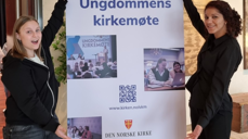Helene Viken Hovlan og Sylviane Jacques Denis deltok på UKM frå Møre. Synstolkning: bilete av Helen og Sylviane som står foran eit banner for UKM.