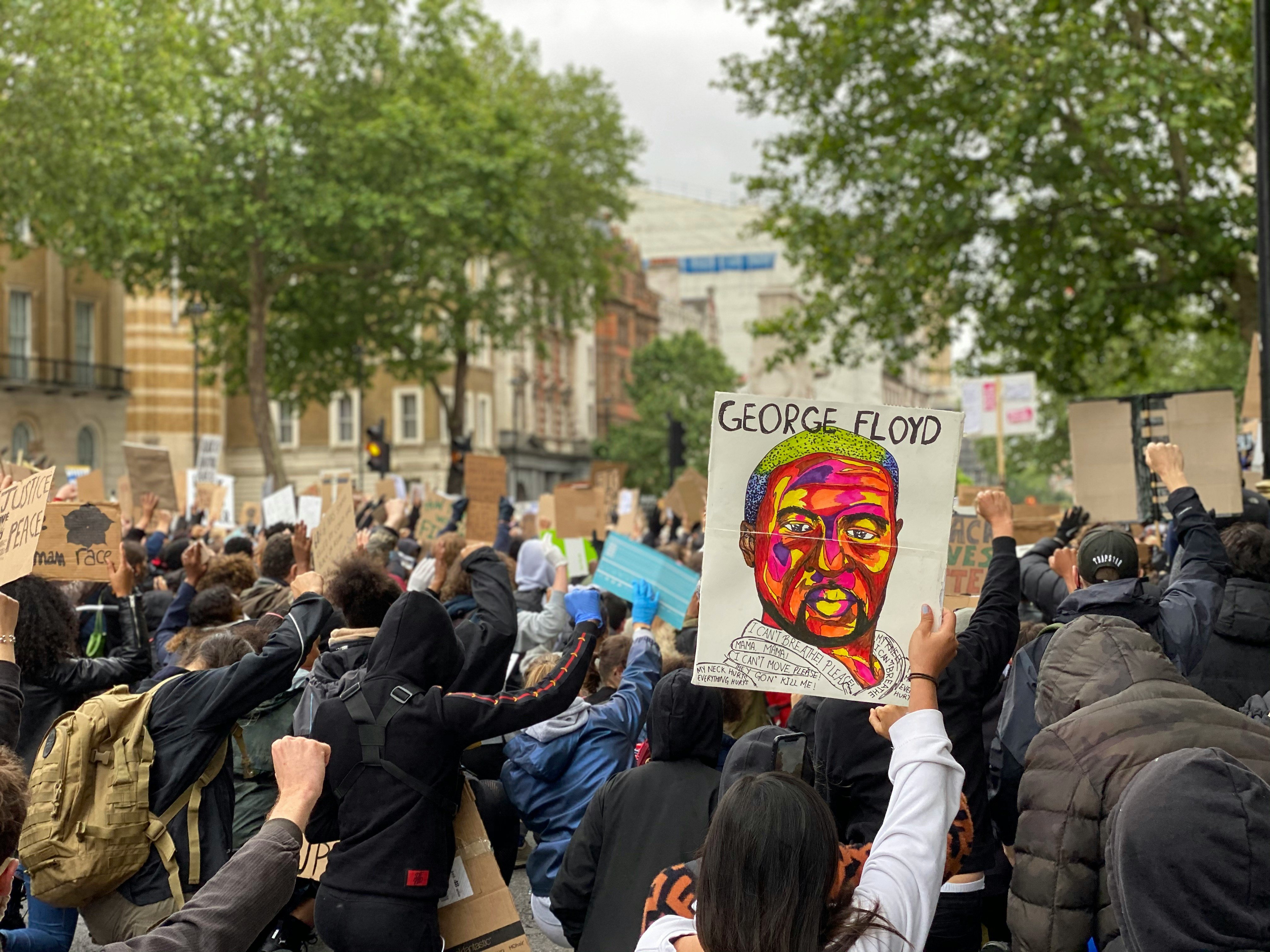 En person holder en plakat med ansiktet til George Floyd i en folkemasse under en Black Lives Matter-demonstrasjon i Downing Street, London, 6 juni 2020.