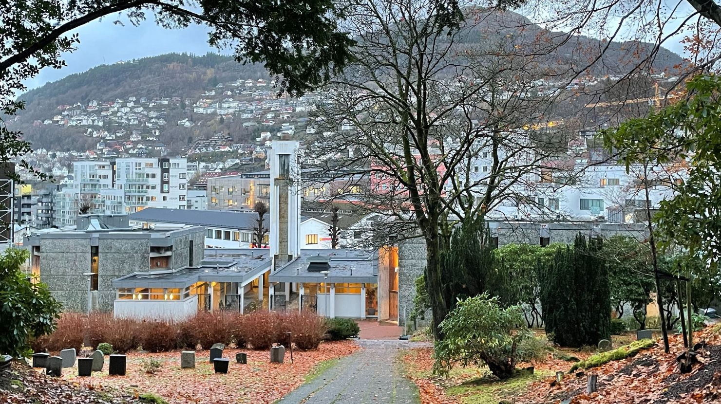 høstbilde av krematorium og kapell med byen i bakgrunnen. Foto.