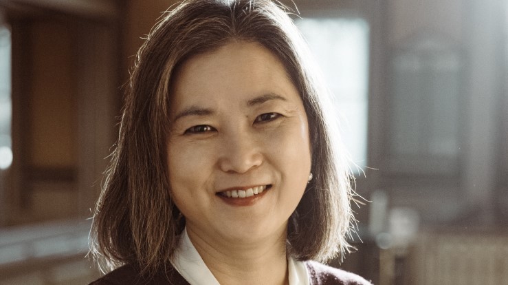 En kantor som ser inn i kameraet og smiler lett. 