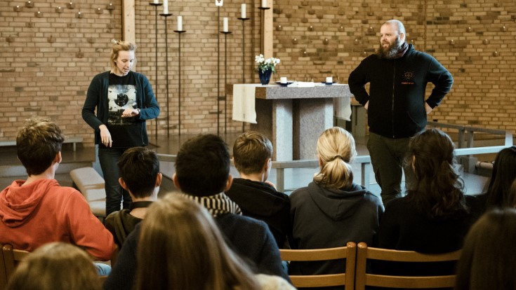 En kateket står foran en gjeng konfirmanter. 