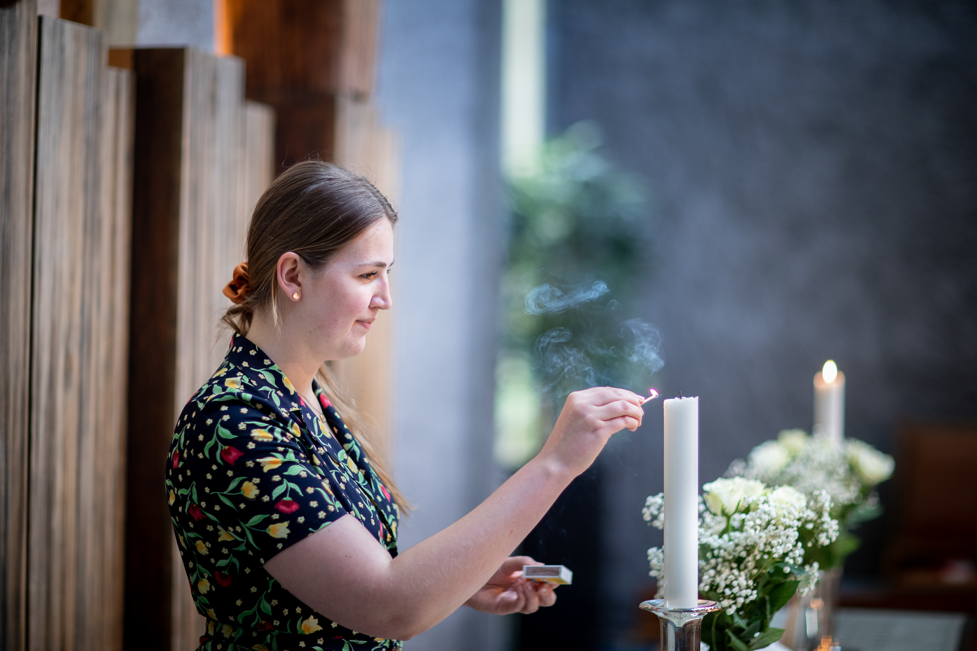 En kirketjener som tenner et lys i kirken