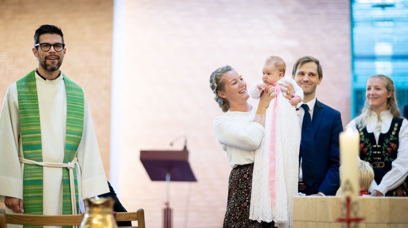 Det nydøpte barnet holdes opp foran menigheten