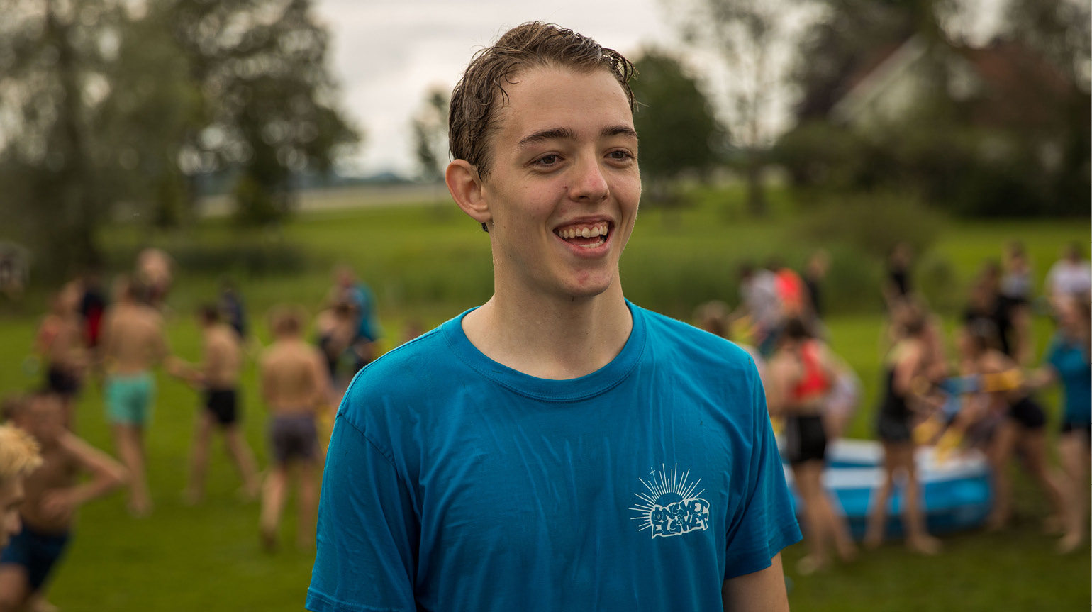 Gutt smiler, det er vannkrig i bakgrunnen på konfleir.