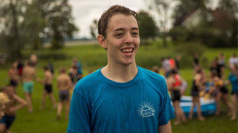 Gutt smiler, det er vannkrig i bakgrunnen på konfleir.