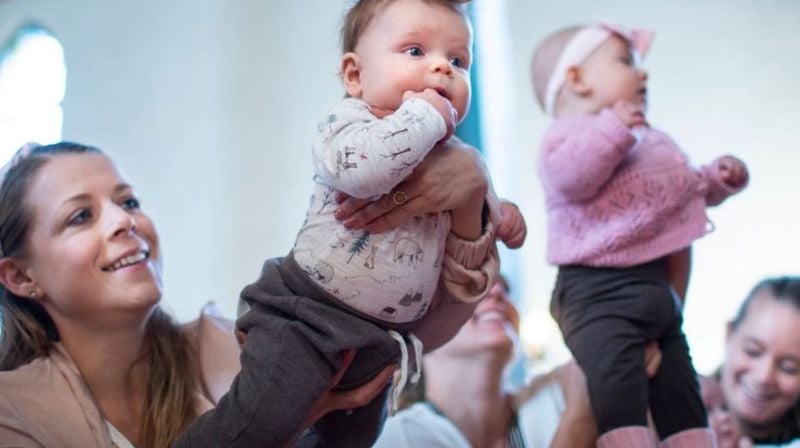 To barn holdes høyt opp i været av sine foreldre. De er på babysang og opplever å være nært andre mennesker og bli kjent med kirken.