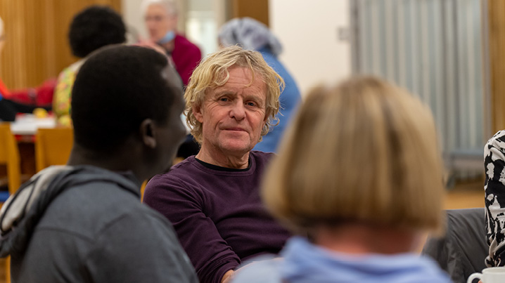 En gruppe mennesker sitter i ring i kirken og snakker sammen