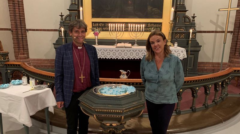 Biskop Stein Reinertsen og Tania Michelet ved døpefonten i Trefoldighetskirken i Arendal. Foto: Dag A. Kvarstein
