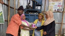 PRESSE: Her står Jemilla Senbete (nr 2 f.v.) med venner foran pressen som de har fått støtte av Kirkens Nødhjelp til å skaffe. De presser plastflaskene sammen, som siden blir remser det flettes kurver av.