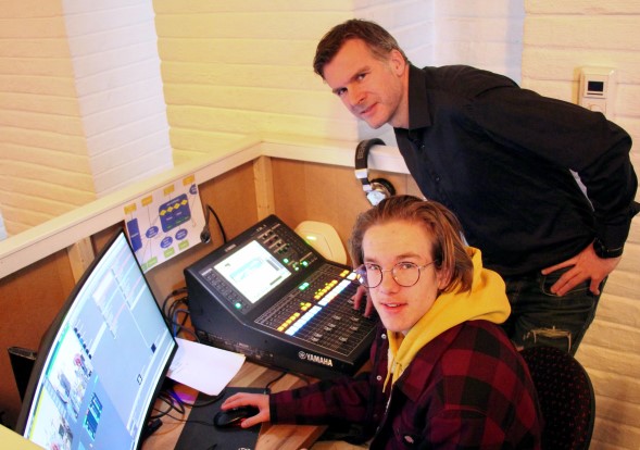 Far og sønn Samset i Greverud kirkes digitale kommando-sentral. Junior Birk Mathis styrer kameraer, mens pappa Eigil holder orden på tekstene som vises på alterveggen. Foto: Erling Omvik