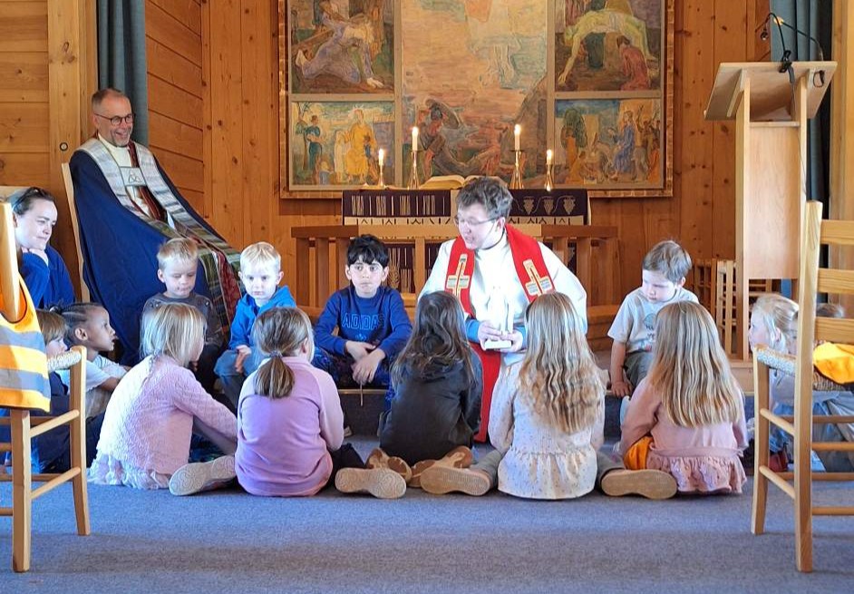 Sokneprest Benjamin Fjellheim Olsen samlar ungane i Sødorp kapell under gudstenesta den siste visitasdagen. Foto: Venke Sletten