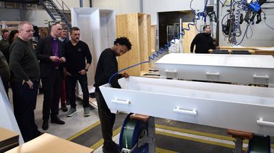 Biskopen besøkte kistebedriften Trosterud Freno som produserer 86% av kistene til begravelser i Norge. Foto: Toten Idag/OA.