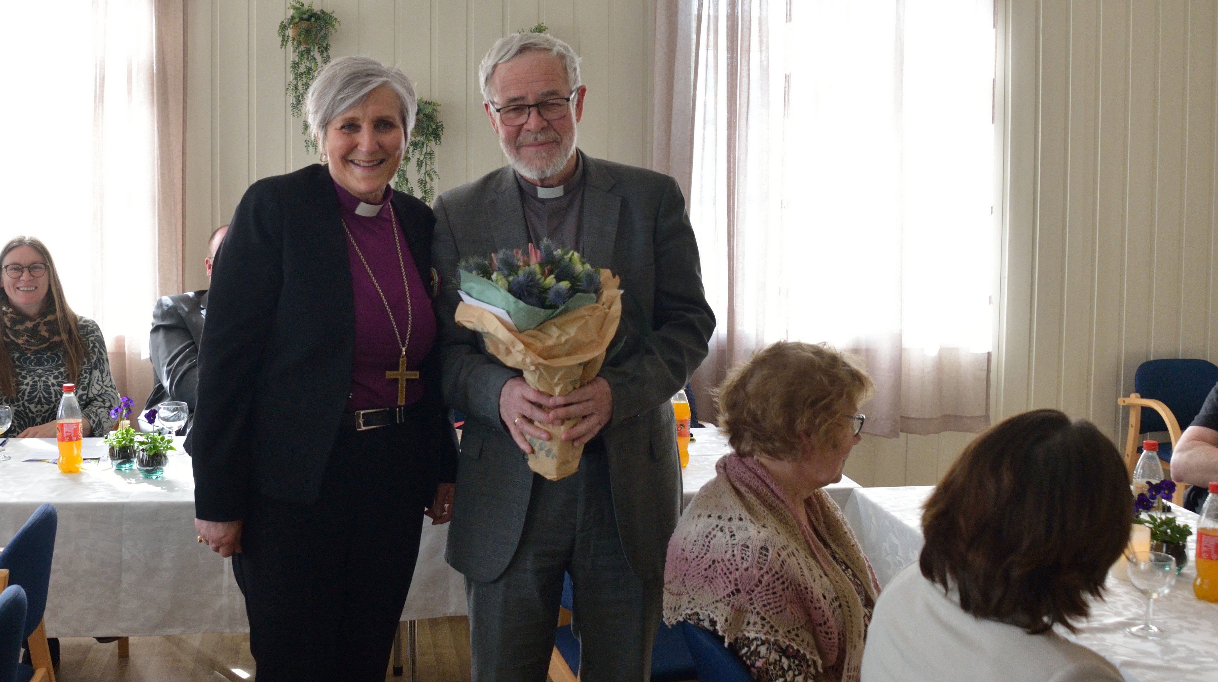 Biskop Herborg delte ut velfortjente blomster til Gustav Danielsen under kirkekaffen på bispevisitasens avslutningsdag (Foto: Svein Tore Kolstad)