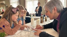 Fellesskap over bordet på siste visitasdag i Namdalseid. Biskop Herborg løser oppgaver sammen med Agnes og Frida Westerhus under kirkekaffen i Solhaug grendehus (Foto: Tina Møllersdatter Solbakken)