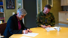 Biskop Herborg Finnset og oberst Ole Marius Tørrisplass signerer samarbeidsavtalen. Den første i sitt slag.
