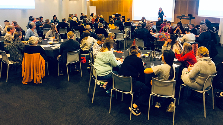 Trosopplæringsrådgiver Vigdis Aanderaa Aakre (på scenen) fra Nidaros bispedømmeråd kunne ønske 85 Nidaros-ansatte velkommen til årets Nidarossamling på Gardermoen. (Foto: Aud Kristin Aasen)