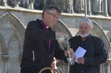 Tomm Kristiansen følger nøye med når biskop Tor Singsaas gjør klar flasken med vann som er på vei fra Svalbard til Klimatoppmøtet i Paris