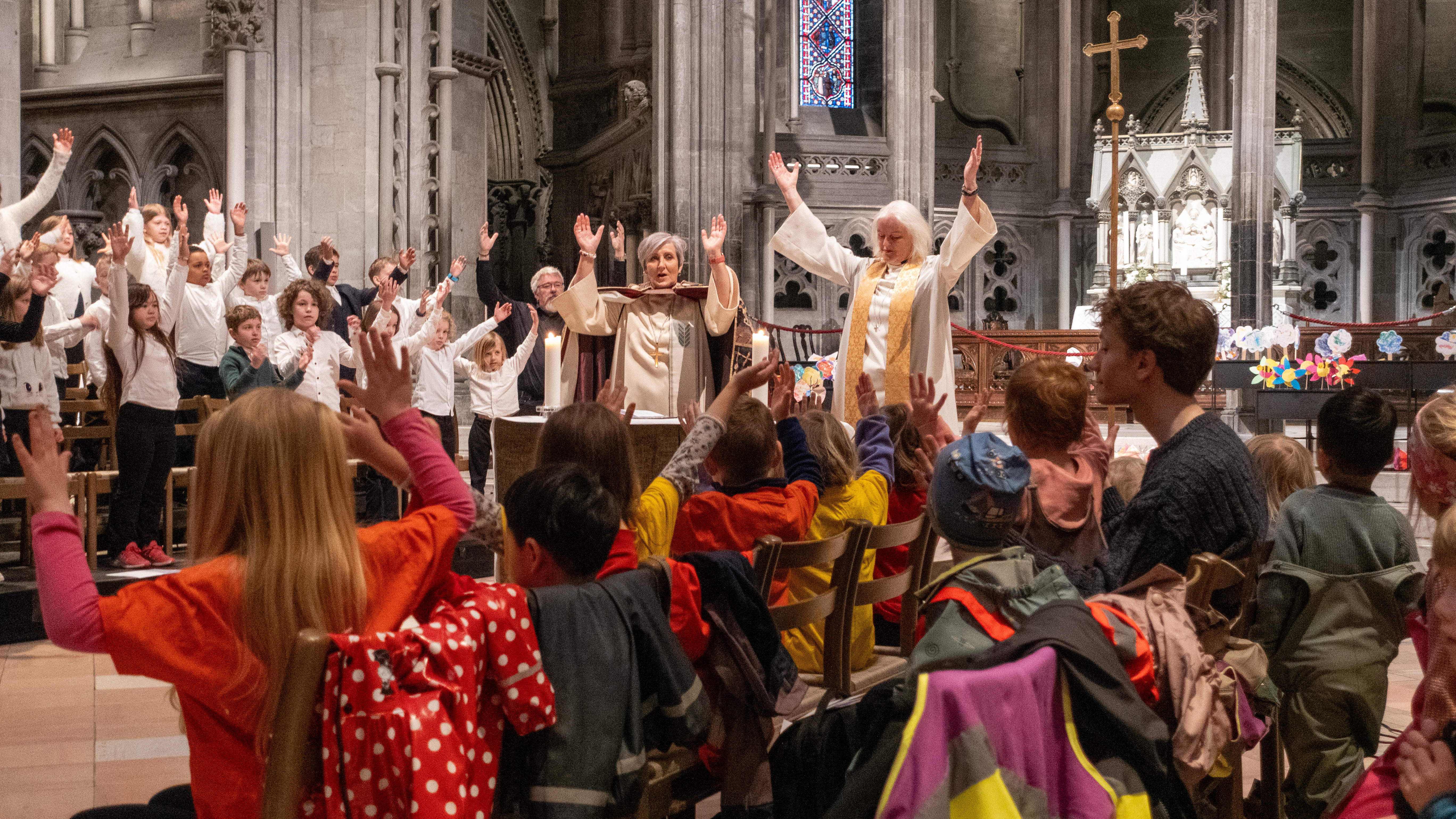Biskop Herborg Finnset og kapellan Marie Farstad ledet an i salmen «Måne og sol» under den første av tre barnehagegudstjenester i Nidarosdomen denne dagen. I bakgrunnen står aspirantene fra Nidarosdomens guttekor og jentekor (Foto: Magne Vik Ravndal)
