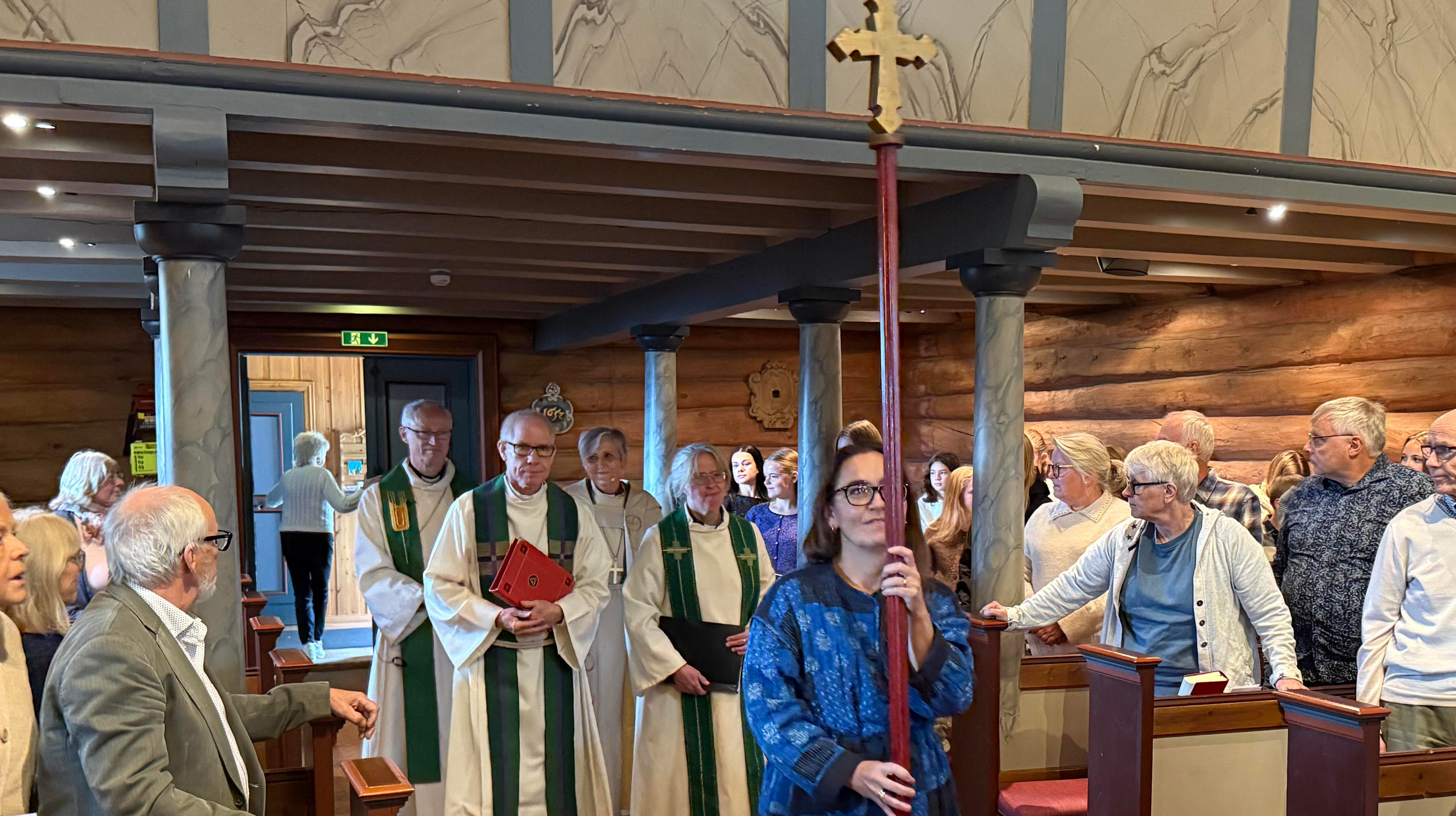 Biskopens vandringen og visitas gjennom Oppdal og Lønset endte i den avsluttende gudstjenesten i Oppdal kirke. Biskop Herborg Finnset (bak til høyre) gikk inn i den fullsatte kirken sammen med Prost Øystein Flø (bak til venstre), sokneprestene Øyvind Vognild og Kristine Berg og kirkeverge Aina Volden (forrest med prosesjonskorset). (Alle foto: Aud Kristin Saltvik Aasen)