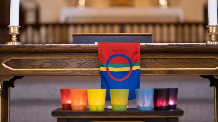 Samisk flagg med fargerike lys på et alter