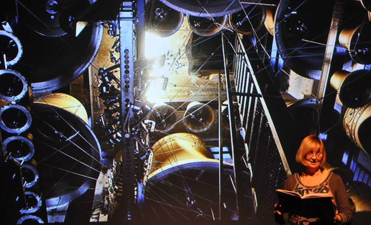 Reidun Mæsel Kolvik leser fra "Pax", mens Johanne Seines Svendsens bilder vises i bakgrunnen. Arrangementet foregikk i litteratursalen på Stormen bibliotek. Foto: Thoralf Fagertun