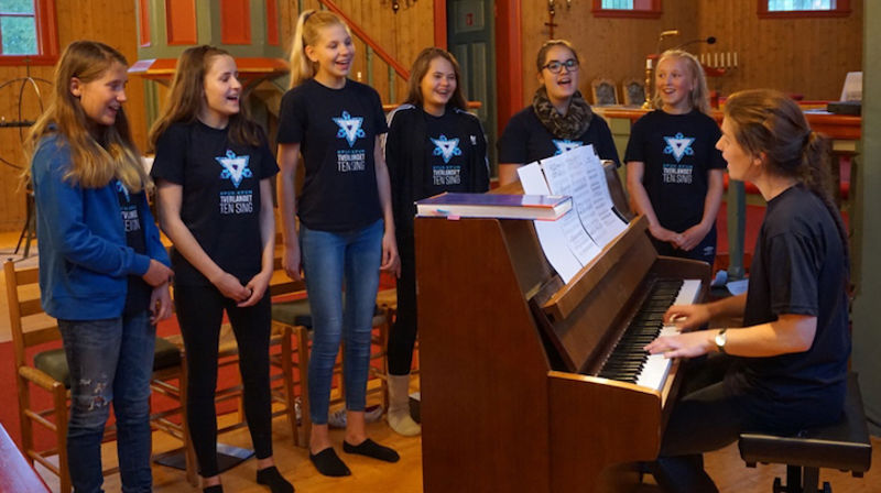 Tverlandet Ten Sing avdeling Murmansk. Fra venstre: Liva Lie Tverbakk, Jenny Lovise Jenssen, Rachel-Emilie Kjellbakk, Celina Mari Torrissen, Lotte Sjåvik, Kamilla Karlsen. Dirigent Linn-Marie Estensen sitter ved pianoet. Mats-Andre Alfredsen blir også med østover, men var ikke til stede da bildet ble tatt. Foto: Thoralf Fagertun