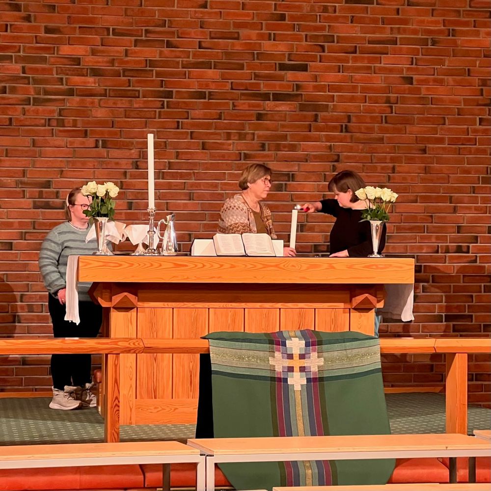 Deltakere i inkluderingsarbeidet og diakoniarbeider Hilde Gudmundsen tente alterlysene på visitasgudstjenesten.