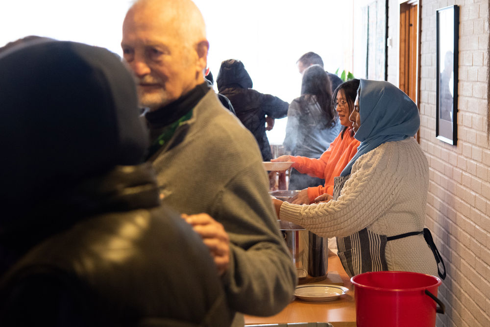 Gul, i blå hijab, og Ida (bak) følger opp med suppeservering. Opp mot 200 porsjoner øses opp hver uke.