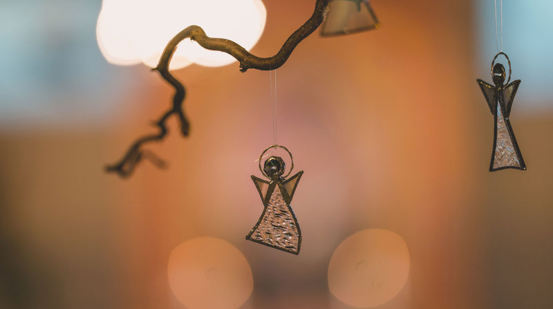 Glassengel som henger i en gren bakerst i Askim kirke. Foto: Noiva Photography