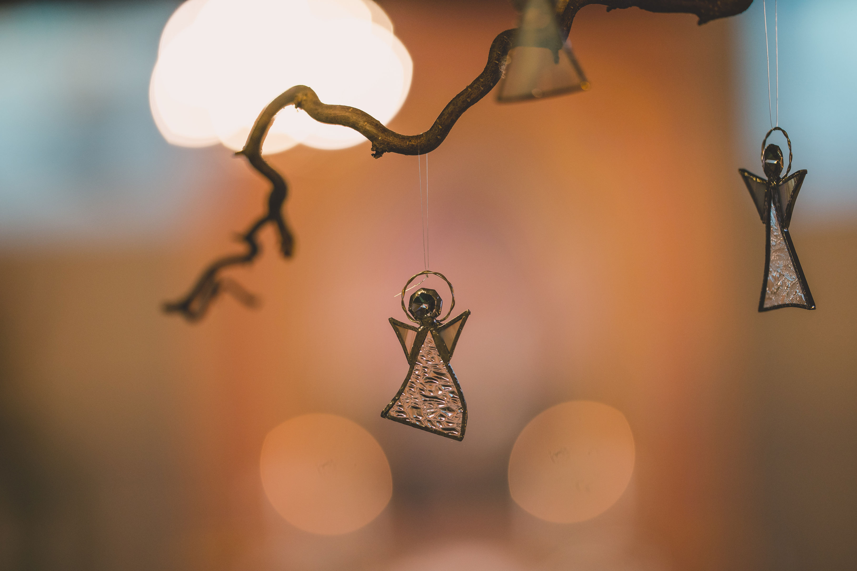 Glassengel som henger i en gren bakerst i Askim kirke. Foto: Noiva Photography