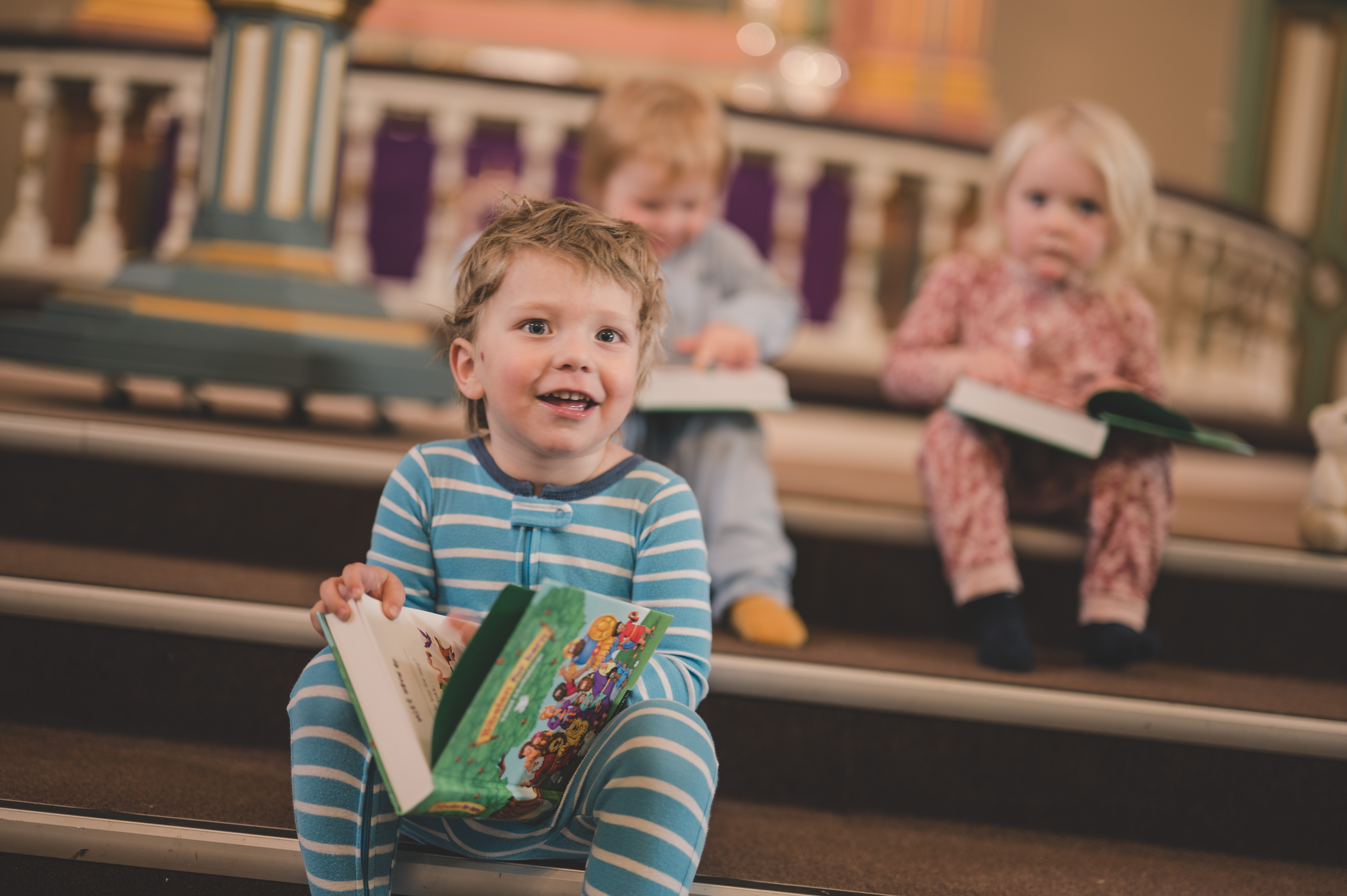 3 fornøyde 3-åringer som har fått utdelt en barnebibel. Foto: Noiva photography