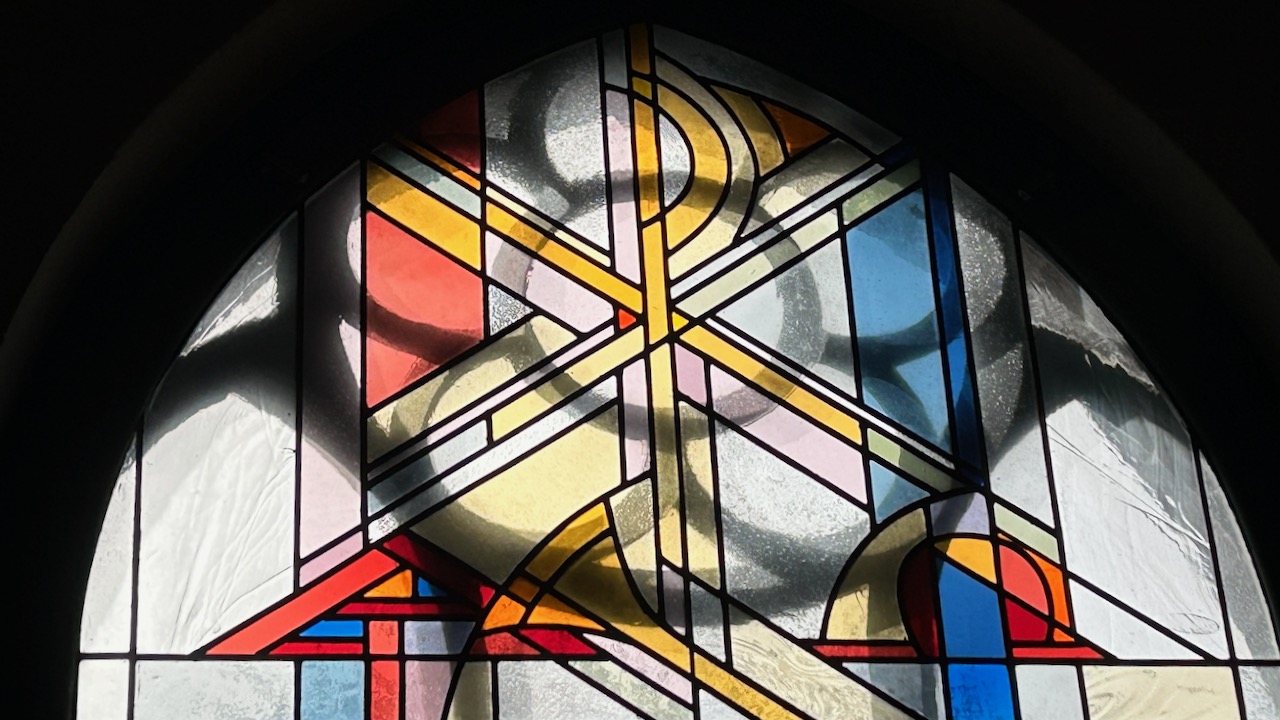 Kristusmonogram i ett av de nye glassmaleriene.