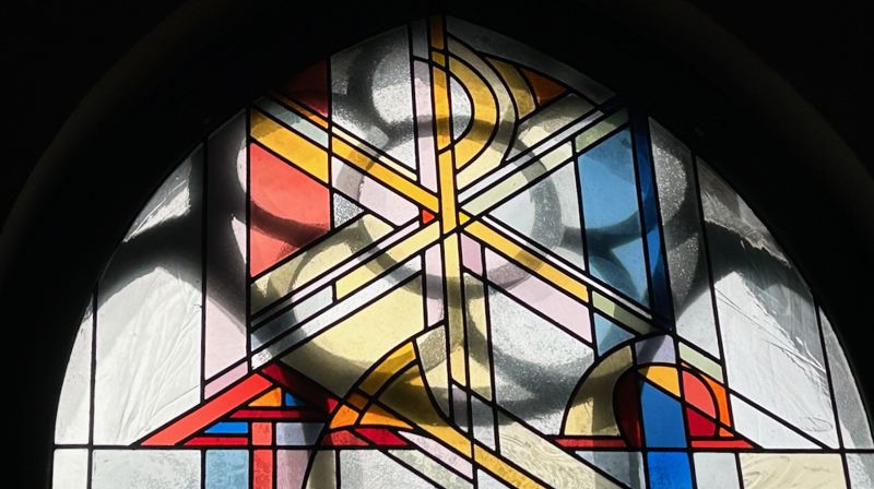 Kristusmonogram i ett av de nye glassmaleriene.