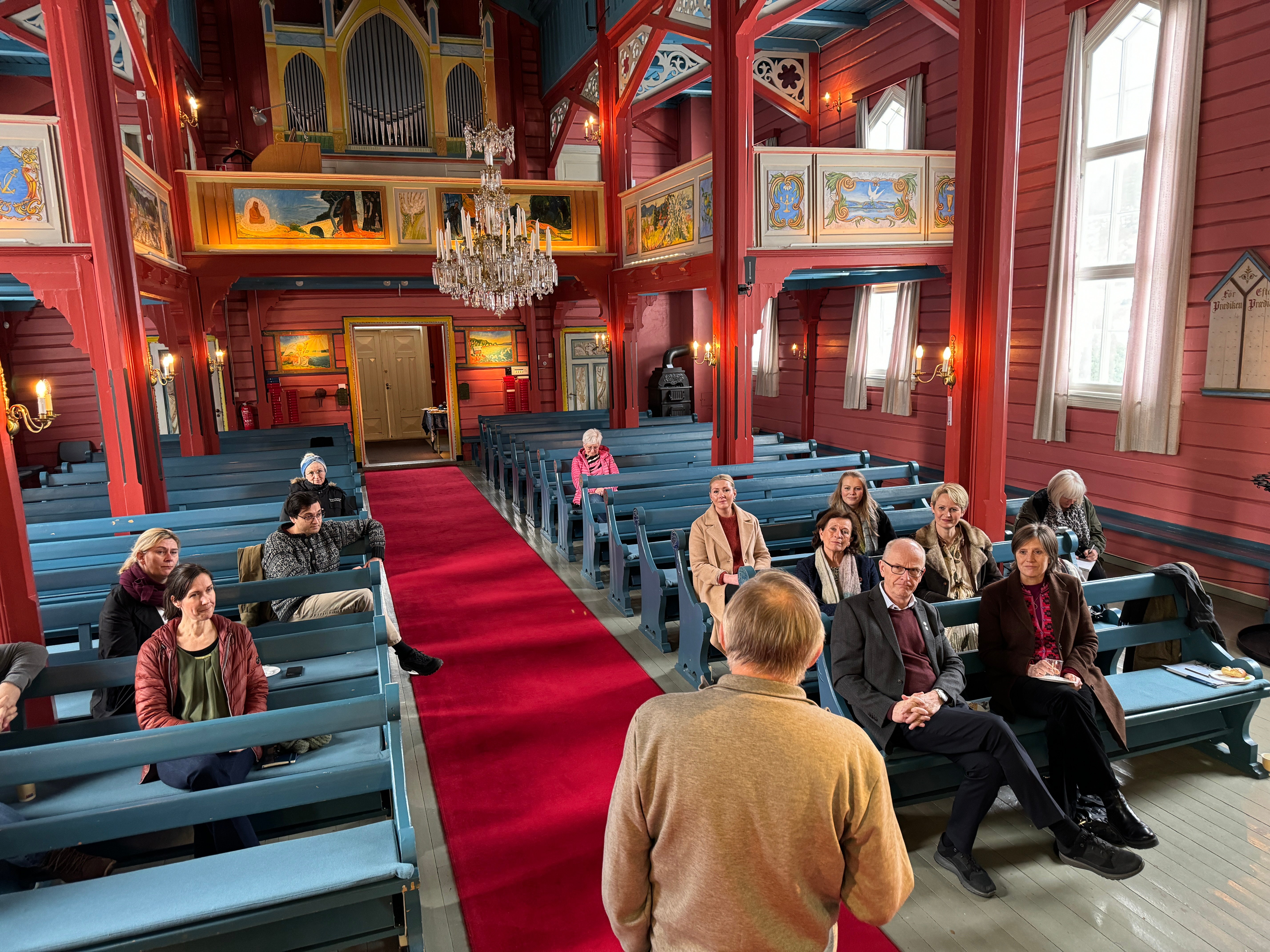 Frank Tangen forteller statsråd Toppe og følget om Holmsbu kirkes historie, utsmykning og tilknytning til kunstnerkolonien i Holmsbu. Foto: Asker kirkelige fellesråd