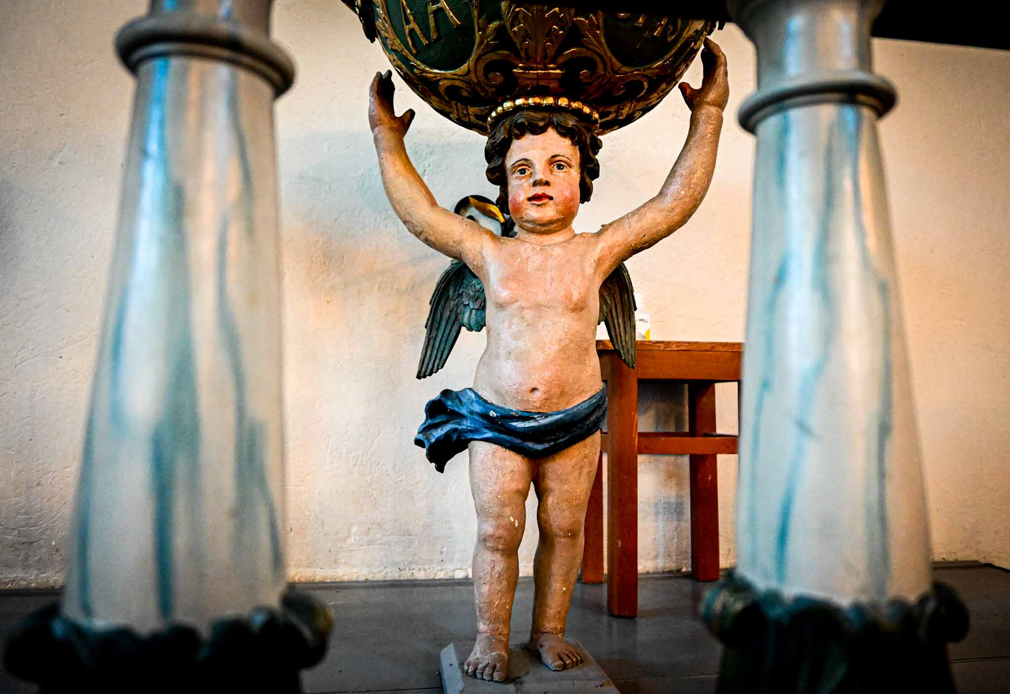 Bildet viser engelen som bærer skålen på døpefonten i Asker kirke. Døpefonten er fra 1705 og er laget av tre. Kunstner er Lars Sivertsen, som også har laget prekestolen og altertavlen. Foto: Jørgen Svartvasmo / Asker kirkelige fellesråd