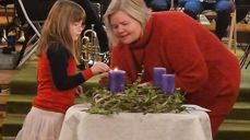 Kyrkjevergje Monica Finden og barn tenner adventskransen
