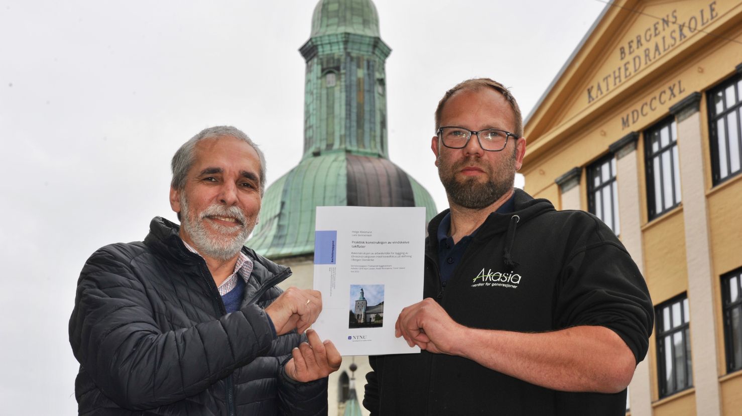 Kirkebyggsjef Arne Tveit sammen med Akasias Helge Kleemann. I bakgrunnen ser vi taket på Bergen domkirke som Kleemann har skrevet oppgave om.