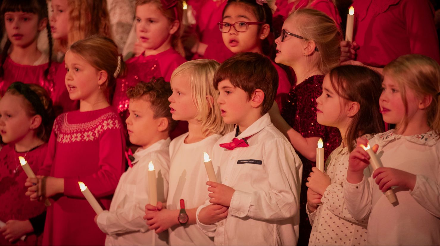 Julekledd barnekor synger i kirke. Foto.