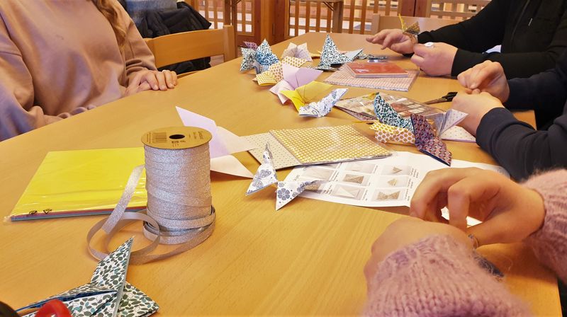 Ungdom som lager papir-sommerfugler